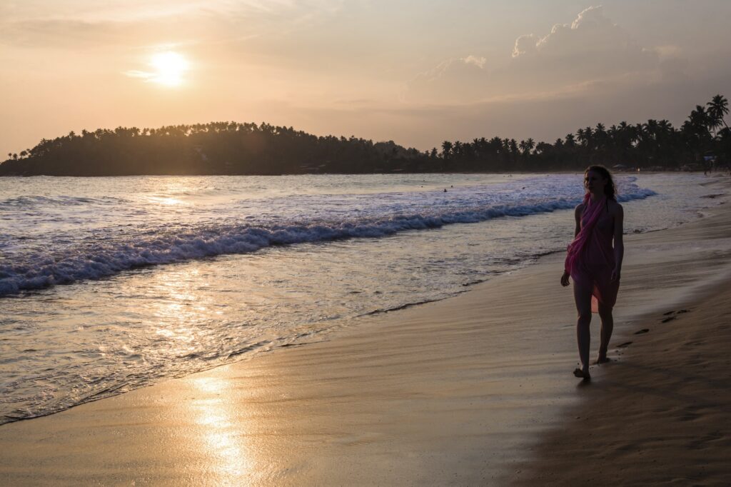 Mirissa, woman on holiday on Mirissa Beach at sunset, South Coast of Sri Lanka, Southern Province, A