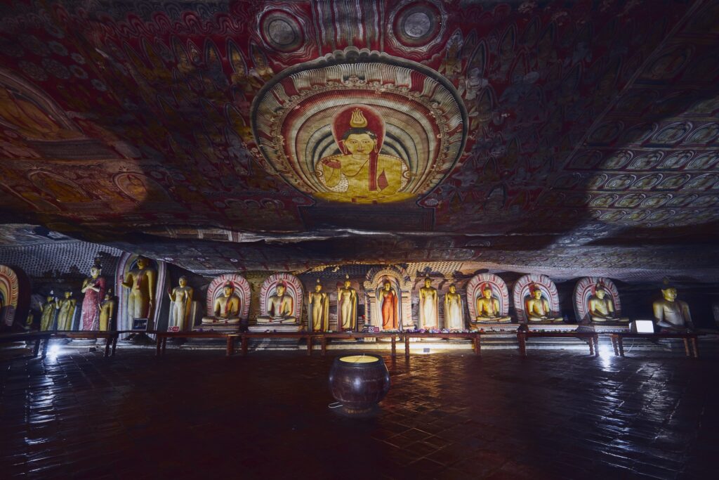 Statues and paintings inside of largest and best preserved cave temple complex in Sri Lanka